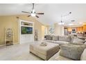Inviting living room features vaulted ceilings, tile floors, and a comfortable sectional sofa at 8932 Village Green Blvd, Clermont, FL 34711