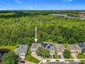 Beautiful aerial view of a home backing to a lush green forest and a distant lake in the community at 9454 Candice Ct, Orlando, FL 32832