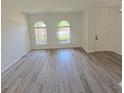 Open-concept living room featuring updated floors, arched windows, and neutral paint at 9982 Shadow Creek Dr, Orlando, FL 32832