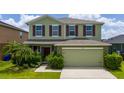 Charming two-story home featuring lush landscaping, an attached two car garage, and an inviting facade at 1951 Betsy Ross Ln, St Cloud, FL 34769