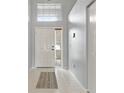 Bright entryway with tile flooring, a white front door, and transom window above for natural light at 10473 Glassborough Dr, Orlando, FL 32825