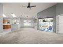 Open living room with vaulted ceilings, large windows, access to the screened lanai, and a ceiling fan at 10473 Glassborough Dr, Orlando, FL 32825