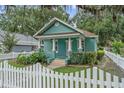 Charming home with a white picket fence and lush landscaping at 121 W Oakland Ave, Oakland, FL 34760