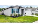 Charming single-story home with lush lawn, dark mulch landscaping, and a two-car garage at 1351 Fox Squirrel Dr, Davenport, FL 33897