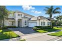 Beautiful home with a three-car garage, manicured lawn, and stone detailing on the facade at 13924 Jomatt Loop, Winter Garden, FL 34787