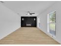 Bright living room with hardwood floors, a modern fireplace, and ample natural light from the windows at 1484 Lake Francis Dr, Apopka, FL 32712
