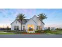 Stunning exterior view of the community clubhouse with decorative stone accents, a black roof, and palm trees at 1510 Ridgeback Ln, Apopka, FL 32703