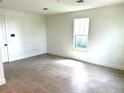 Neutral-toned bedroom with tile floors, a bright window, and ample space at 15125 Grove Lake Dr, Winter Garden, FL 34787