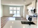 Bright kitchen features white cabinets, stainless appliances, a kitchen island, and wood floors at 15125 Grove Lake Dr, Winter Garden, FL 34787