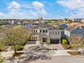 Gorgeous two-story home featuring a paved driveway and a grand entrance with stone accents at 1526 Euston Dr, Reunion, FL 34747