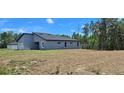 Rear exterior of a single-Gathering home featuring a minimalist design with gray siding at 15300 Sw 62Nd Ct, Ocala, FL 34473