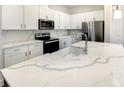 Bright kitchen featuring white cabinets, stainless steel appliances, and marble-look countertops at 1537 Heritage Pl, Oviedo, FL 32765