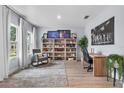 Inviting home office space with custom shelving, a comfortable rocking chair, and abundant natural light at 17676 Passionflower Cir, Clermont, FL 34714