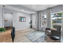 Bright home office featuring large windows with views, light wood floors, and a comfortable gray rocking chair at 17676 Passionflower Cir, Clermont, FL 34714