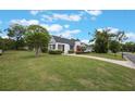 Inviting white home with a red front door, a lush lawn, and mature landscaping at 2101 Lily Ct, Sanford, FL 32771