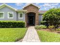 Inviting front entrance with a stone archway and professionally landscaped garden at 2588 Gabrielle Woods Pl, Oviedo, FL 32765