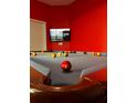 Vibrant game room featuring a well-lit billiard table with a striking red accent wall at 312 Famagusta Dr, Davenport, FL 33896