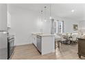 Bright kitchen with stainless steel appliances, an island with bar seating, and a dining area at 312 Famagusta Dr, Davenport, FL 33896