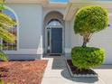 Close-up showcasing the arched entryway and the meticulously landscaped front yard at 3713 Becontree Pl, Oviedo, FL 32765