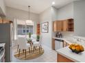 Cozy kitchen nook featuring modern appliances, warm wood cabinets, and a sunlit dining area at 3713 Becontree Pl, Oviedo, FL 32765