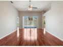 Spacious living room featuring gleaming hardwood floors and sliding glass doors to the patio at 3713 Becontree Pl, Oviedo, FL 32765
