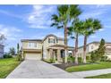 Inviting home boasts a manicured lawn, mature palm trees and neutral color scheme at 4123 Oaktree Dr, Davenport, FL 33837