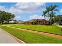 A charming single story home with well-manicured landscaping and mature palm trees on a sunny day at 5306 Crane Hill Ct, St Cloud, FL 34771