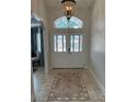 Welcoming foyer with decorative tile flooring, glass-paneled double doors, and elegant lighting fixtures at 5416 Bay Side Dr, Orlando, FL 32819