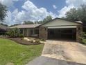Spacious home with a two-car garage and well-manicured lawn under a cloudy sky at 5935 Sheryl Anita St, Oviedo, FL 32765