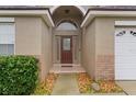 Inviting front porch with a decorative glass door, enhanced by manicured landscaping and stone accents at 8102 Pomo Dr, Kissimmee, FL 34747