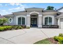Inviting front entrance with a gray facade, arched doorway, and decorative glass doors at 8122 Westminster Abbey Blvd, Orlando, FL 32835