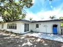 Back of house with back door, sliding glass doors and shaded patio at 9148 Oakwood Dr, Lake Wales, FL 33898