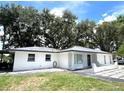 Beautiful single-story home featuring a white exterior, gray roof, and a well-maintained lawn at 9148 Oakwood Dr, Lake Wales, FL 33898