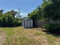 Storage shed in the partially shaded, spacious back yard with a wooden fence at 2315 Pembrook Dr, Orlando, FL 32810