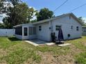 The rear of this single story house has an enclosed porch with a concrete patio at 2315 Pembrook Dr, Orlando, FL 32810