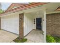Inviting entryway featuring a covered porch, brick accents, and tiled flooring leading to the front door at 111 Tarrytown Trl, Longwood, FL 32750