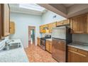 Bright kitchen featuring a skylight, stainless steel appliances, light countertops, and wood cabinets at 111 Tarrytown Trl, Longwood, FL 32750