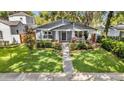 Beautifully landscaped front yard leading to a gray craftsman style home at 1217 Kenwood Ave, Winter Park, FL 32789
