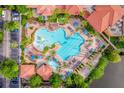 Aerial view of the luxurious resort swimming pool with abundant lounge chairs and palm trees at 12527 Floridays Resort Dr # E104, Orlando, FL 32821