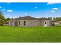 View of the house and its covered patio, and the lawn in the backyard at 12756 Sw 80 St, Dunnellon, FL 34432