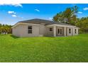 View of the house and its covered patio, and the lawn in the backyard at 12756 Sw 80 St, Dunnellon, FL 34432