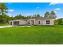 Charming single-story home with a three-car garage and a beautifully landscaped front yard at 12756 Sw 80 St, Dunnellon, FL 34432