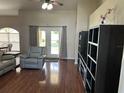 Cozy living room with french doors, featuring hardwood floors, comfortable seating, and stylish built-in shelving at 13000 Sandy Pine Ln, Clermont, FL 34711