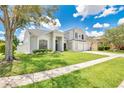 Beautiful two-story home with lush green lawn, mature tree, and brick accents at 13691 Crystal River Dr, Orlando, FL 32828