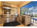 This outdoor kitchen is equipped with a grill, counter space, stainless steel drawers, and a vent hood at 1428 Solana Cir, Davenport, FL 33897