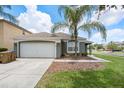 Charming single-story home with a well-manicured lawn and a beautiful palm tree in the front yard at 150 Barefoot Beach Way, Kissimmee, FL 34746