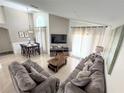 Bright living room featuring tall ceilings, lots of natural light and tile floors at 150 Barefoot Beach Way, Kissimmee, FL 34746