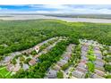 An aerial view of the property with mature trees, lake and community neighborhood in a lush setting at 1646 Song Sparrow Ct, Sanford, FL 32773