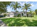 Beautiful home with palm trees, a lush green lawn, and well-maintained landscaping at 189 Blackstone Creek Rd, Groveland, FL 34736