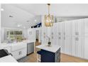 Modern kitchen with stainless appliances, an island, white cabinets, and an open floor plan at 189 Blackstone Creek Rd, Groveland, FL 34736